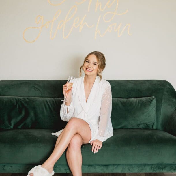 a woman sitting on a couch holding a drink. Photo by Bushel + Peck Photo, Texas Wedding Photographers