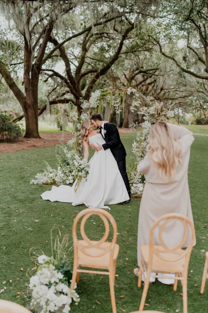a man and woman kissing under a tree, How to Choose A Wedding Photographer
